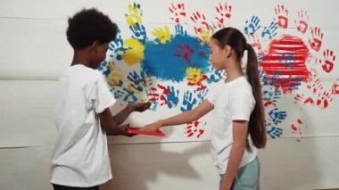 Sevimli kız ve mutlu Afrikalı çocuk elini renkli tepsiye koyup lekeli duvara damgaladı. Çeşitli lise öğrencileri el yazısıyla bölümler boyuyor ya da sanat dersinde yaratıcı aktiviteler yapıyor. Öğretim