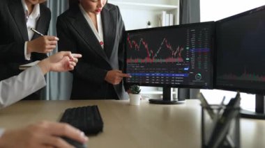 Hisse senedi borsası pazarlamasını analiz eden yavaş çekim şirketindeki yatırımcılar, kayıp için mum bar fiyatını analiz eden monitörlere bakıyor ve kazanç ve kâr elde ediyor. Filizlenen