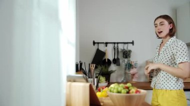 Mutlu genç anne mutfakta dururken salata kasesine sebze koydu. Çekici beyaz bir kadın yemek pişirmekten ve sabah taze organik yemek yapmaktan ya da ev yemeği yapmaktan zevk alır. Pedagoji.