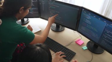 Yavaş çekim arkası yazılım geliştirici mühendisi bilgisayar programlama için birlikte çalışarak hata ayıklama kodunu çözüyor, ofiste monitörde karmaşık algoritmaları çözüyor. Filizlenen
