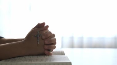 Hristiyan katolik takipçilerle dinsel bağlılık ve maneviyat duygusu doludur. Ağır çekimde Hristiyan, Tanrı 'ya ibadet etmek için dua ederken kutsal haçı tutuyor. Filizlenen