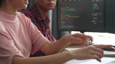 Yavaş çekim arkası yazılım geliştirici mühendisi bilgisayar programlama için birlikte çalışarak hata ayıklama kodunu çözüyor, ofiste monitörde karmaşık algoritmaları çözüyor. Filizlenen
