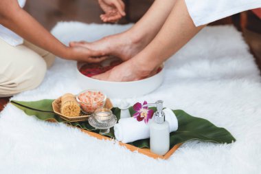 Adam lüks kaplıcalarda mutlu ayak masajına devam ederken, masör de hafif gün ışığı atmosferinde refleksoloji terapisi ya da otel ayak spa 'sında. Sessiz.