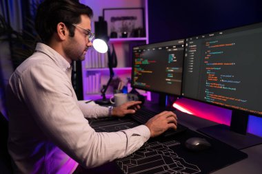 İki pc ekranda veri yazılım geliştirme analizi yapan akıllı bilişim geliştiricisi, neon ışıklı siber ofiste güncellenmiş uygulama programı güncellenmiş online web sayfası sistemi yaratıyor. Tahmin et..