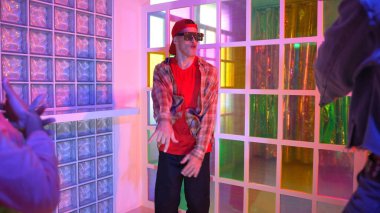 Kafkas dansçısı dans ederken çeşitli arkadaşları gece kulübünde neon ışıkta ayak seslerine bakıyor. Çoklu etnik kökenli hipsterin serbest stil müziğe geçişi ve mutlu bir adamın kameraya bakışıyla. Mutluluk.