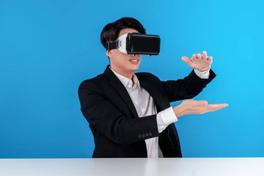 Asyalı işadamı VR 'ı kullanarak veri nesnesini havada tutuyor iş dünyasının fütüristik yenilikçi teknolojisini analiz ediyor izole edilmiş mavi telif uzayındaki sanal gerçekliği inceliyor. Entrika.