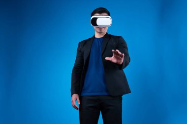 VR kulaklık takan profil işadamı, sanal gerçeklikte mavi arkaplan fütüristik teknolojisini izole eden ilginç verilerle slayta dokunarak metaevren aramasını bağlamaya çalışıyor. Entrika.
