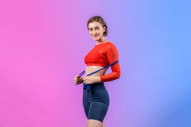 Vücut uzunluğunun tamamı atletik ve sportif genç bir kadın tarafından izole edilmiş arka planda ip atlarken çekildi. Sağlıklı aktif ve vücut bakımı yaşam tarzı.