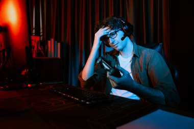 Stresli genç oyun flaması takımı bilgisayar savaşında Esport 'un joystick' i ile oynuyor. Daha zor kaybedilen oyunu kazanmak için radyonun neon ışıklı modern odasında bir sonraki strateji planı deneniyor. Toplayıcı.
