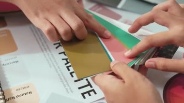Grafik tasarımı için renk seçimi yapan ve beyin fırtınası yapan iki tasarımcının yavaş çekim çekimi ya da tasarım bürosunda kromatik danışmanlık hizmeti isteyen bir müşteri. Değiştirilmiş