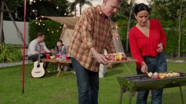 Aile hep birlikte bahçede kamp kurar, yaşlı bir çift barbekü yapar, yemek yer. Son sınıflar kamp faaliyetlerini kullanırlar, doğayla iç içe olurlar ve genç nesil çapraz kuşaklarla zaman geçirirler. Uyumsuzluk.