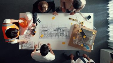 Becerikli mühendis ekibinin ev inşaatından bahsedişinin en alt görüntüsü. Mimar ya da tasarımcı grubunun planlar hakkında beyin fırtınası yapmak için tartışan ve yazan hava görüşü. Hizalama.