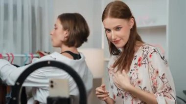 İki kadın nüfuzlu kişi canlı yayın yapan video klip eleştirisi kıyafetlerini sosyal medyada ya da blogda yayınlıyor. Stüdyo ışıklandırmalı mutlu genç kız çevrimiçi pazarlama oturumu yayını için..