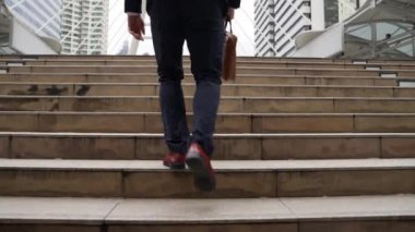 Şehir manzarasıyla çevrili merdivenlerden çıkan işadamlarının bacakları. Hırslı proje yöneticisinin modern inşaatta zorlu bir iş ya da yatırım fırsatı bulması. Urbane.