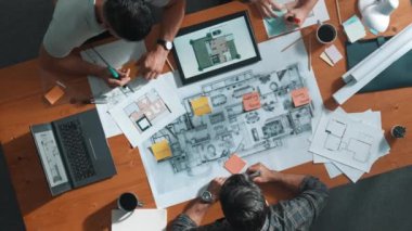 Bina planına bakarken inşaat mühendisinin elindeki belgelerin en alttaki görüntüsü. Mimarlık takımının fikir üretme ve planlama alanındaki hava görüşü masada planlı otururken. Sempozyum.