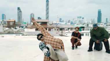 Çatıda çok kültürlü arkadaşlar varken profesyonel İspanyol break dansçısı B boy dansı. Genç modern dans grubu hip hop hareketi yapıyor. Tarz, moda, aksiyon. Açık hava sporu 2024 hiphop..