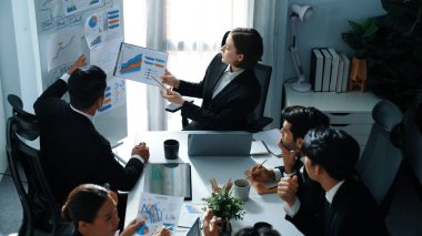 Akıllı yöneticinin üst görünümü, kurul ve kağıt arasındaki grafiği karşılaştırırken aynı zamanda başlangıç projesini iş toplantısında çeşitli takımlardan oluşan bir grupla birlikte planlıyor. Beyin fırtınası yapan ve birlikte çalışan takım. Müdürlük.