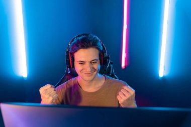 Kazanmak için çevrimiçi oyun oynayan akıllı flama makinesinin sunucu kanalı, neon ışıklı odada seçilen takım yarışması için izleyicilerle birlikte canlı yayında canlı yayında kulaklık takıyor. Bireysel.