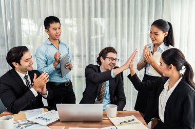 Bir grup mutlu iş adamı beşlik bir jest ve başarılı bir takım çalışması yapıyor. Çeşitli yarış bürosu çalışanları şirket ofisinde pazarlama planlamasında ilerleme kaydettikten sonra kutlama yapıyorlar. Çok titiz.