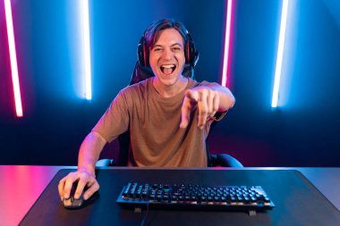 Kazanmak için çevrimiçi oyun oynayan akıllı flama makinesinin sunucu kanalı, neon ışıklı odada seçilen takım yarışması için izleyicilerle birlikte canlı yayında canlı yayında kulaklık takıyor. Bireysel.