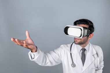 Zeki doktor, kameraya bakıyor ve beyaz arka planda duruyor. Sanal gerçeklik ya da metadünya giyerken tıbbi verileri elinde tutan ve kontrol eden beyaz bir doktor. Yenilik teknolojisi. Sapma.