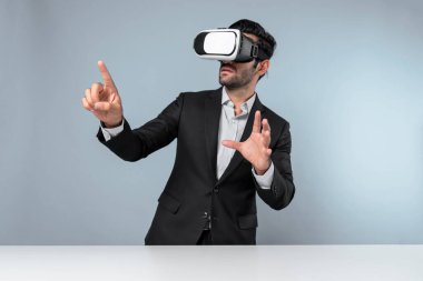 Akıllı yönetici veri analizine işaret ederken VR gözlüğü kullanarak veriye bakıyor. Beyaz yatırımcı takım elbise ve sanal gerçeklik kulaklığı takarken metaevreni birbirine bağlıyor. Yenilik teknolojisi. Sapma.