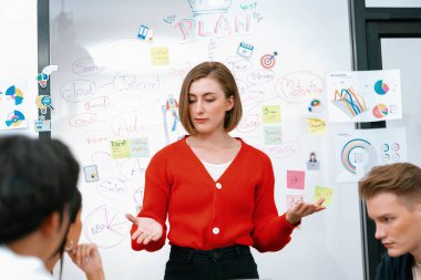 Profesyonel çekici kadın lider, modern iş toplantı odasında beyin fırtınası zihin haritalama istatistikleri ve renkli yapışkan notlar kullanarak yaratıcı pazarlama planını sunuyor. Tertemiz..