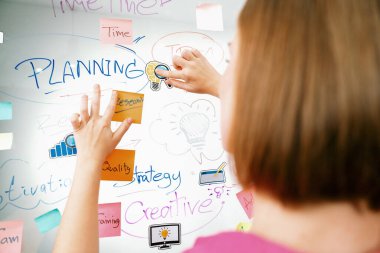 Profesyonel iş kadınının elini kapat ve iş planını sunarken renkli yapışkan notları beyaz tahtaya yapıştır. Yaratıcı iş toplantısı ve beyin fırtınası konsepti. Tertemiz..