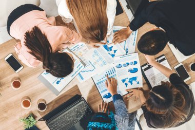 Modern ofisteki iş adamları ve iş kadınlarıyla grup toplantısındaki iş adamlarının en üst düzey görüşü, masada dizüstü bilgisayar, kahve ve belge ile. Kurumsal şirketler uds