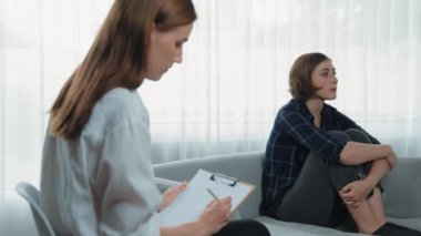 Psikologla ruh sağlığı terapisi gören üzgün travma sonrası stres bozukluğu olan bir kadın. Yaşam sonrası depresyon veya keder. Hayal kırıklığına uğramış genç bir kadın klinikteki duygular hakkında prim psikoloğuyla konuşuyor.