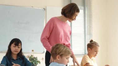 Enerjik zeki öğretmen sınıftaki beyaz çocuğa sınıf çalışmasını anlatırken aynı zamanda çok kültürlü bir öğrencinin derste dinlemesini ve çalışmasını anlatıyor. Aktif öğretmen sınav ya da sınıf çalışmasından bahsediyor. Pedagoji.