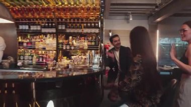 Lüks bir barda VIP müşterisi olan zeki bir barmen sıcak bir gece kulübünün ışıklandırma atmosferinde canlı bir sohbet için tezgahta yeni ve güzel bir konuğu selamlıyor. Vinosity.