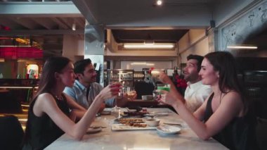 Grup arkadaşı ya da çift masada kokteyl içerken garson da lüks bir restoranda özel ızgara et menüsü sunuyor. Vinosity.