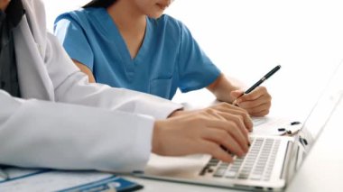 Hastane masasında birlikte çalışan ve tıbbi tedavi planlayan çeşitli profesyonel sağlık görevlileri. Takım çalışması başarılı hastalıklara ve hastalıklara yol açar. Ağır çekim. Katı.