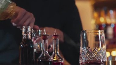 İçki şekerini ölçmek için elinde jigger tutan yakın el barmeni bardakları karıştırmak için alkol hazırlama yaratıcı karışım. Gece hayatı karışımı sergilenen özel bir içecek. Vinosity.