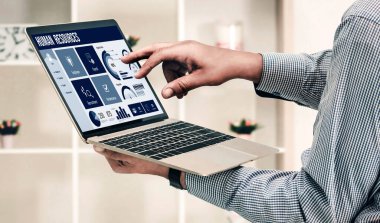 Human resources management software on computer screen helping human resources employee to manage recruitment, payroll, staff searching and KPI evaluation snugly