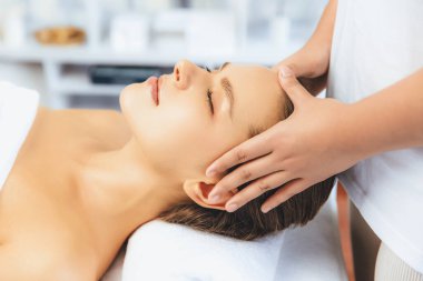 Kafkasyalı kadın stres önleyici kafa masajından ve lüks tatil beldesi ya da otel spa salonundaki modern ışık ortamında yüz güzelliği eğlencelerini şımartmaktan hoşlanıyor. Sessiz.