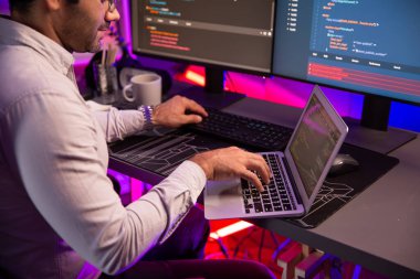 Akıllı IT geliştiricisi, yazılım kodlama sisteminde Neon Light ofis odasında yazı yazmak için çalışıyor, uygulama programı güncellemesi en son online web sitesi veritabanını çevrimiçi yapıyor. Tahmin et..