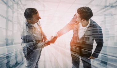 İş adamlarının arka plandaki belediye binasında el sıkışması ortaklık anlaşmasının başarısını gösteriyor. Kurumsal takım çalışması, güven ortağı ve iş anlaşması kavramı. uds