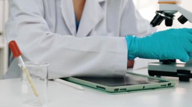 Laboratuvar kimya araştırmacısı mikroskop kullanarak yeni ilaç ya da tedavi geliştirir. Laboratuvar mikrobiyoloji ekipmanları ile bilimsel uzmanlık ile sağlık hizmetlerinin teknolojik gelişimi. Ağır çekim. Katı.