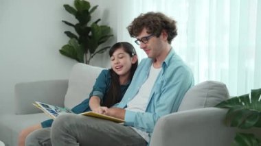 Beyaz bir baba ve tatlı bir kız kanepede otururken masal kitabı okuyorlar. Mutlu bir baba, sevimli bir Amerikan çocuğuna, birlikte zaman geçirirken hayal gücünün gelişmesi için hikaye anlatıyor. Pedagoji.