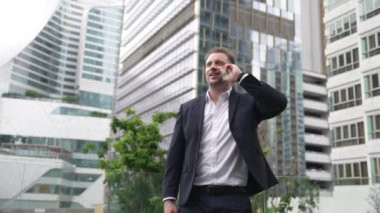 Yetenekli bir iş adamı pazarlama ekibiyle pazarlama stratejisi hakkında konuşurken gökdelende dururken telefon kullanıyor. Mutlu yönetici, modern kentsel şehirdeki satışları arttırmak için meslektaşını arıyor. Urbane.