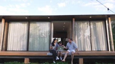 Şirin baba, anne ve kızı birlikte evin bahçesinde oturuyorlar. Ebeveynler, çevre farkındalığıyla ilgili genç nesli iletişim kurmak için açık hava aktivitelerini kullanırlar. Uyumsuzluk.