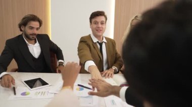 Çeşitli ofis çalışanları, işyerindeki iş sinerjisini ve üretken takım çalışmasını sembolize eden süslü ofis odasında el ele tutuşuyorlar. İş çalışanları arasındaki işbirliği ve birlik.