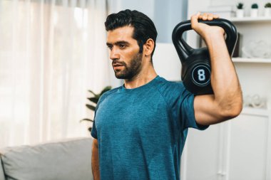 Atletik vücut ve aktif sporcu, sağlıklı vücut çalışma yaşam biçimi konsepti olarak eğlence evinde kas kazancı için kettlebell ağırlığını kaldırıyor..