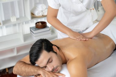 Kafkas erkek müşteri stres önleyici spa masajının keyfini çıkarıyor ve lüks otel veya oteldeki gündüz açık hava ortamında güzellik derisi eğlencesi ile şımartıyor. Sessiz.