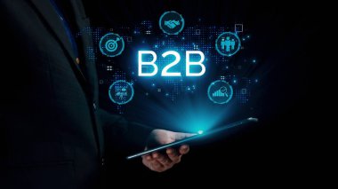 İş adamı B2B peyzajında geziniyor, iş-iş bağlantılarını geliştirmek için kullanım teknolojisi kullanıyor. B2B etkileşimini yeniden şekillendiren keşifler, iş-iş stratejilerinde yenilikleri yönlendiren araçlar. Kullanıcı Kimliği