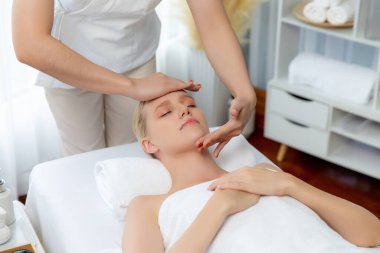 Kafkasyalı kadın stres önleyici kafa masajından ve lüks tatil beldesi ya da otel spa salonundaki modern ışık ortamında yüz güzelliği eğlencelerini şımartmaktan hoşlanıyor. Sessiz.