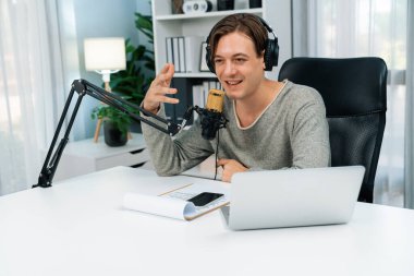 Sunucu kanalı, gülümseyen akıllı yayıncı kaydı, senaryosu ve akıllı telefonuyla sosyal medyada sohbet programı, kulaklık takarak modern ev stüdyosundaki video flamalarını kaydediyor. Bireysel.