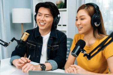 Gülümseyen radyo etkili sunucular, kulaklık takarak sosyal medya kanalından canlı yayın yapıyorlar ve sabah saatlerinde stüdyo kaydında dinleyicilere konu ve dizüstü bilgisayar üzerinden konuşuyorlar. İnfobahn.